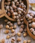 Hazelnuts in bowls over wooden — Stock Photo