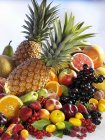 Pineapples with heap of fresh fruits and berries — Stock Photo