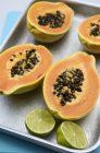 Halved papayas and lime — Stock Photo