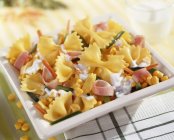 Farfalle pasta with sweetcorn and of ham — Stock Photo