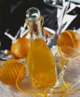 Closeup view of homemade orange liqueur in glass bottle — Stock Photo
