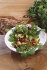Зимовий салат: мінеральний салат з пастернатними чіпсами та журавлиною на білій тарілці — стокове фото