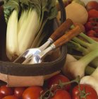 Fresh organic vegetables and garden tools in trug — Stock Photo