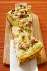 Two pieces of leek and bacon quiche on chopping board — Stock Photo