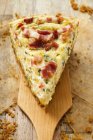 Piece of leek and bacon quiche on wooden server — Stock Photo