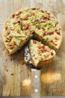 Leek and bacon quiche, a piece cut over wooden surface — Stock Photo