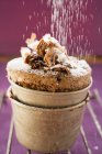Closeup view of sprinkling icing sugar on chocolate souffle — Stock Photo