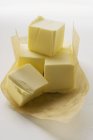 Vue rapprochée des cubes de beurre sur papier — Photo de stock
