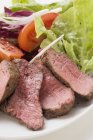 Steak de boeuf, tranché, avec salade — Photo de stock