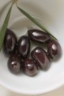 Чорні оливки з гілочкою в білій мисці — стокове фото