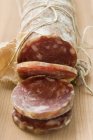 Italian salami with slices cut — Stock Photo