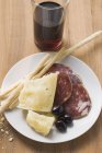 Salame con formaggio e grissini sul piatto — Foto stock