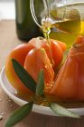 Налить оливковое масло на помидоры — стоковое фото