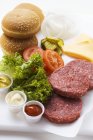 Ingredients for cheeseburgers on board — Stock Photo
