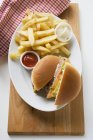 Halved cheeseburger with chips — Stock Photo
