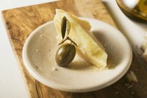 Vista de cerca del queso de oliva y queso parmesano en platillo - foto de stock