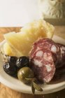 Olives with sliced sausage and Parmesan — Stock Photo