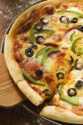 Pizza con queso, salami y pimientos - foto de stock