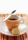 Vista de perto da xícara de café expresso com colher e bola doce no pires — Fotografia de Stock