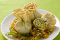 Wontons with mango chutney on white plate over green surface — Stock Photo