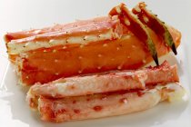 Vista de primer plano de patas de cangrejo rey cocidas en plato blanco - foto de stock