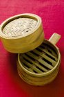 Closeup view of opened bamboo steamer on red cloth — Stock Photo