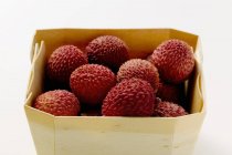 Lychees in woodchip basket — Stock Photo