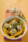 Scallops with pumpkin puree and thyme on white plate over towel — Stock Photo