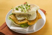 Kürbis-Mozzarella-Sandwich auf weißem Teller mit Handtuch über Holztisch — Stockfoto