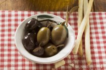 Black and green Olives with grissini — Stock Photo