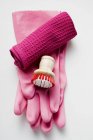 Vista superior de cerca de guantes de goma rosa, cepillo y toalla - foto de stock