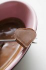 Fondue de chocolate con chocolate en forma de corazón - foto de stock