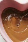 Primo piano vista della fonduta di cioccolato con caramelle a forma di cuore sulla forchetta fonduta — Foto stock