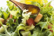 Verser de l'huile d'olive dans la salade — Photo de stock