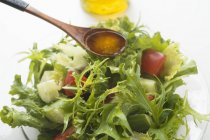 Olivenöl in Salat gießen — Stockfoto