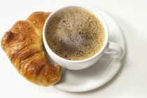 Cup of coffee and croissant — Stock Photo