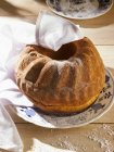 Closeup view of Gugelhupf with sugar icing and tea towel — Stock Photo