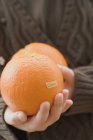 Femme tenant des oranges biologiques — Photo de stock