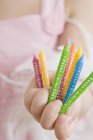 Closeup view of girl holding colorful birthday candles — Stock Photo