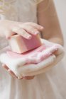 Cropped view of girl holding soap and towel — Stock Photo