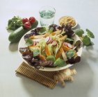 Салат із сурімі з огірком та весняною цибулею на білій тарілці над солом'яним килимком — стокове фото