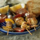 Closeup view of three grilled kebabs with meat and vegetables — Stock Photo