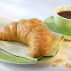 Croissant und eine Tasse Kaffee — Stockfoto