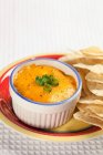 Crab and Artichoke Dip with Tortilla Chips in white pot over plate — Stock Photo
