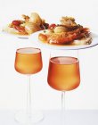 Primo piano vista di due piatti di frutti di mare in cima a bicchieri di vino — Foto stock