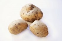 Three fresh and washed potatoes — Stock Photo