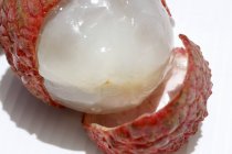 Half-peeled fresh ripe lychee — Stock Photo