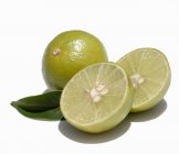 Two limes whole and halved — Stock Photo