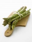 Green asparagus on chopping board — Stock Photo