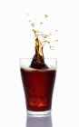 Nahaufnahme von Cola, die aus einem Glas spritzt — Stockfoto